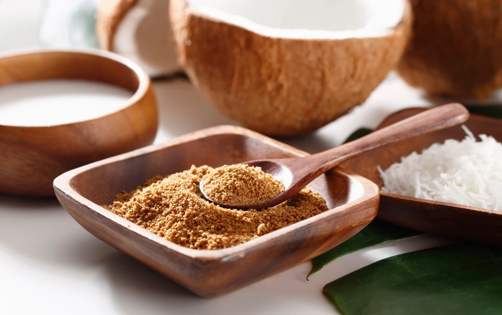 Coconut sugar in bowl and spoon with fresh coconut background